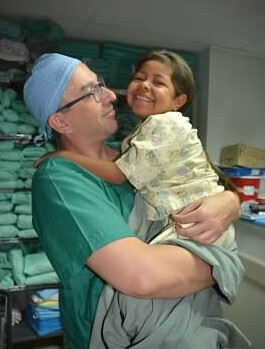 Dr. Mallios holds young patient post-surgery