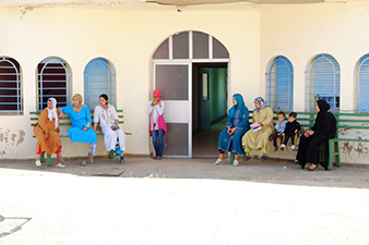 Several women and children are waiting outside Moroccan medical clinic