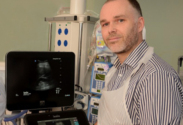 Dr. Justin Kirk-Bayley with a Sonosite ultrasound machine