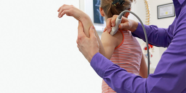 Girl being scanned for a fracture by a ultrasound machine